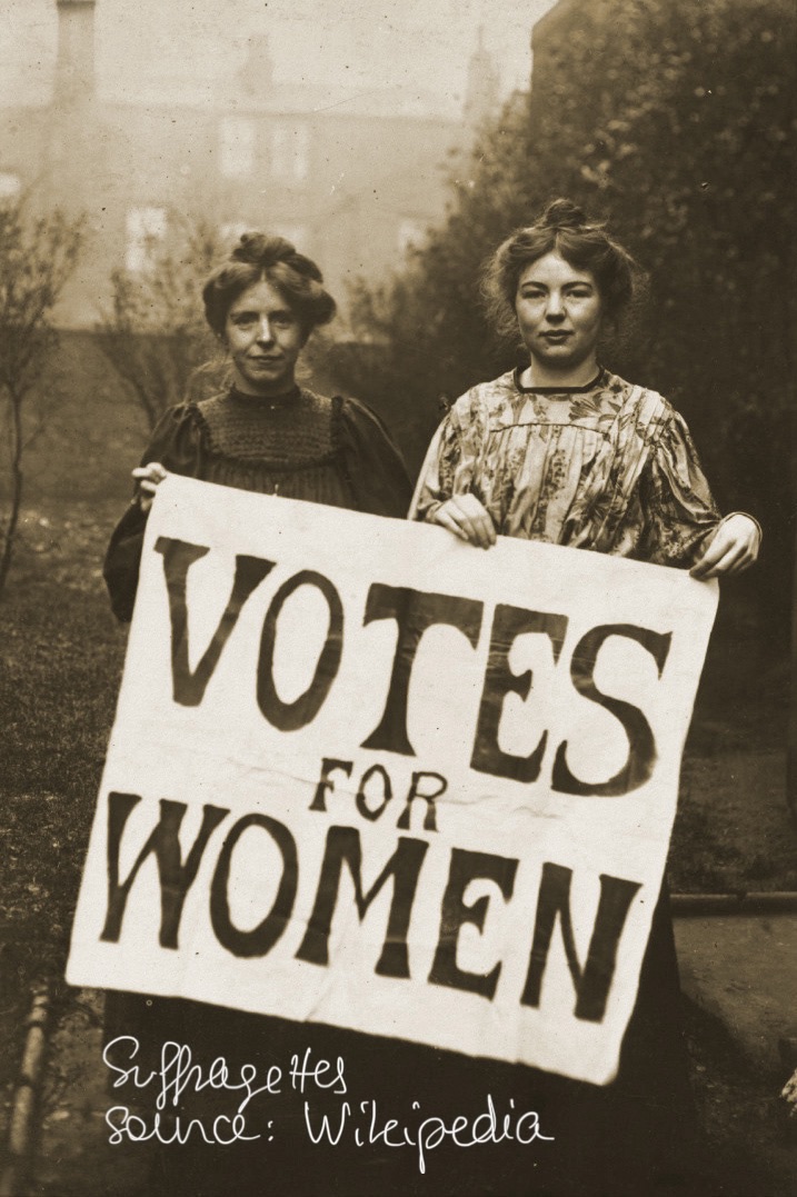Suffragettes portant une pancarte "Votes for women"